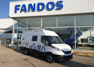 Furgoneta nueva, 
IVECO Camper,
Modelo  35S16A8V de 12m3,
Con cambio automático Hi Matic de 8 velocidades.  IVECO Daily Camper, una de las opciones más amplias del segmento con un espacio habitable de 12 metros cúbicos, con una longitud de 6 metros y una altura interior de 1,9 m. No obstante, estas dos últimas cifras pueden crecer hasta los 2,1 m de altura y 18 m3 de capacidad. Su carrocería presenta una amplia puerta corredera en el lateral derecho, escalón posterior y unas puertas traseras con apertura de 270º, sin olvidarnos de un habitáculo plano sin obstáculos. Su configuración polivalente permite que hasta 4 pasajeros viajen y pernocten en ella, con dos camas de matrimonio desmontables.  Toma como base la Daily destinada para uso profesional con mecánica diésel 2,3 litros Heavy Duty de 156 CV y 380 Nm de par motor, y cambio automático de 8 velocidades Hi Matic, destacando por ser una de las furgonetas con mayor maniobrabilidad del segmento.  Asimismo, cuenta con diversas ayudas sumamente interesantes para quienes no están acostumbrados a conducir este tipo de vehículos, como es por ejemplo el asistente de viento lateral.  Respecto a su interior, dice la marca que ha empleado materiales ligeros y duraderos basados principalmente en varios tipos de plásticos. Así pues, nos encontramos con un espacio capaz de albergar a cuatro huéspedes perfectamente equipado. La parte trasera se ha pensado de forma modular, pues cumple las funciones de dormitorio con una litera compuesta por dos camas de matrimonio de 198 x 130 cm con un baúl de almacenaje, comedor para esas cuatro personas, así como maletero con capacidad suficiente para guardar en él unas bicicletas o una pequeña motocicleta.  Dispone también de un baño completo con inodoro, lavabo y ducha, además de una cocina con dos fuegos, fregadero de un seno y nevera-congelador de 75 litros, estando todas las “estancias” perfectamente iluminadas gracias a las tres claraboyas y una iluminación interior 100 % LED. En cuanto al abastecimiento, corre a cargo de un depósito de 90 litros de aguas sucias y limpias y de una una placa solar de 160 W, siendo además capaz de suministrar corriente a 220 V con una potencia máxima de 1.500 W.  No obstante, para quienes prefieran tomar el aire fresco incluye un toldo de 3,7 metros y un foco LED bajo el cual poder colocar la mesa y sillas de camping. En el apartado multimedia cuenta con lo más esencial, como es una radio DAB, conexión USB y manos libres Bluetooth, aunque carece de la ya necesaria conectividad Android Auto y Apple CarPlay.