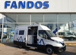 Furgoneta nueva, 
IVECO Camper,
Modelo  35S16A8V de 12m3,
Con cambio automático Hi Matic de 8 velocidades.  IVECO Daily Camper, una de las opciones más amplias del segmento con un espacio habitable de 12 metros cúbicos, con una longitud de 6 metros y una altura interior de 1,9 m. No obstante, estas dos últimas cifras pueden crecer hasta los 2,1 m de altura y 18 m3 de capacidad. Su carrocería presenta una amplia puerta corredera en el lateral derecho, escalón posterior y unas puertas traseras con apertura de 270º, sin olvidarnos de un habitáculo plano sin obstáculos. Su configuración polivalente permite que hasta 4 pasajeros viajen y pernocten en ella, con dos camas de matrimonio desmontables.  Toma como base la Daily destinada para uso profesional con mecánica diésel 2,3 litros Heavy Duty de 156 CV y 380 Nm de par motor, y cambio automático de 8 velocidades Hi Matic, destacando por ser una de las furgonetas con mayor maniobrabilidad del segmento.  Asimismo, cuenta con diversas ayudas sumamente interesantes para quienes no están acostumbrados a conducir este tipo de vehículos, como es por ejemplo el asistente de viento lateral.  Respecto a su interior, dice la marca que ha empleado materiales ligeros y duraderos basados principalmente en varios tipos de plásticos. Así pues, nos encontramos con un espacio capaz de albergar a cuatro huéspedes perfectamente equipado. La parte trasera se ha pensado de forma modular, pues cumple las funciones de dormitorio con una litera compuesta por dos camas de matrimonio de 198 x 130 cm con un baúl de almacenaje, comedor para esas cuatro personas, así como maletero con capacidad suficiente para guardar en él unas bicicletas o una pequeña motocicleta.  Dispone también de un baño completo con inodoro, lavabo y ducha, además de una cocina con dos fuegos, fregadero de un seno y nevera-congelador de 75 litros, estando todas las “estancias” perfectamente iluminadas gracias a las tres claraboyas y una iluminación interior 100 % LED. En cuanto al abastecimiento, corre a cargo de un depósito de 90 litros de aguas sucias y limpias y de una una placa solar de 160 W, siendo además capaz de suministrar corriente a 220 V con una potencia máxima de 1.500 W.  No obstante, para quienes prefieran tomar el aire fresco incluye un toldo de 3,7 metros y un foco LED bajo el cual poder colocar la mesa y sillas de camping. En el apartado multimedia cuenta con lo más esencial, como es una radio DAB, conexión USB y manos libres Bluetooth, aunque carece de la ya necesaria conectividad Android Auto y Apple CarPlay.