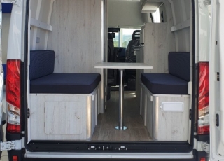 Furgoneta nueva, 
IVECO Camper,
Modelo  35S16A8V de 12m3,
Con cambio automático Hi Matic de 8 velocidades.  IVECO Daily Camper, una de las opciones más amplias del segmento con un espacio habitable de 12 metros cúbicos, con una longitud de 6 metros y una altura interior de 1,9 m. No obstante, estas dos últimas cifras pueden crecer hasta los 2,1 m de altura y 18 m3 de capacidad. Su carrocería presenta una amplia puerta corredera en el lateral derecho, escalón posterior y unas puertas traseras con apertura de 270º, sin olvidarnos de un habitáculo plano sin obstáculos. Su configuración polivalente permite que hasta 4 pasajeros viajen y pernocten en ella, con dos camas de matrimonio desmontables.  Toma como base la Daily destinada para uso profesional con mecánica diésel 2,3 litros Heavy Duty de 156 CV y 380 Nm de par motor, y cambio automático de 8 velocidades Hi Matic, destacando por ser una de las furgonetas con mayor maniobrabilidad del segmento.  Asimismo, cuenta con diversas ayudas sumamente interesantes para quienes no están acostumbrados a conducir este tipo de vehículos, como es por ejemplo el asistente de viento lateral.  Respecto a su interior, dice la marca que ha empleado materiales ligeros y duraderos basados principalmente en varios tipos de plásticos. Así pues, nos encontramos con un espacio capaz de albergar a cuatro huéspedes perfectamente equipado. La parte trasera se ha pensado de forma modular, pues cumple las funciones de dormitorio con una litera compuesta por dos camas de matrimonio de 198 x 130 cm con un baúl de almacenaje, comedor para esas cuatro personas, así como maletero con capacidad suficiente para guardar en él unas bicicletas o una pequeña motocicleta.  Dispone también de un baño completo con inodoro, lavabo y ducha, además de una cocina con dos fuegos, fregadero de un seno y nevera-congelador de 75 litros, estando todas las “estancias” perfectamente iluminadas gracias a las tres claraboyas y una iluminación interior 100 % LED. En cuanto al abastecimiento, corre a cargo de un depósito de 90 litros de aguas sucias y limpias y de una una placa solar de 160 W, siendo además capaz de suministrar corriente a 220 V con una potencia máxima de 1.500 W.  No obstante, para quienes prefieran tomar el aire fresco incluye un toldo de 3,7 metros y un foco LED bajo el cual poder colocar la mesa y sillas de camping. En el apartado multimedia cuenta con lo más esencial, como es una radio DAB, conexión USB y manos libres Bluetooth, aunque carece de la ya necesaria conectividad Android Auto y Apple CarPlay.